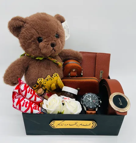 باکس هدیه ولنتاین مردانه کد V167 شامل عروسک خرسی وارداتی اورجینال، کیف پول جیبی چرم Gucci، جاریموتی چرم شیک، جاکارتی چرم زیپ دار، ساعت بند چرم طرح سه موتوره تقویم دار، کمربند ریلی با سگک وارداتی، شکلات خارجی کیت کت، نوتلا کوچک، گل رز معطر، تقویم طلایی و شیشه عشق در هاردباکس